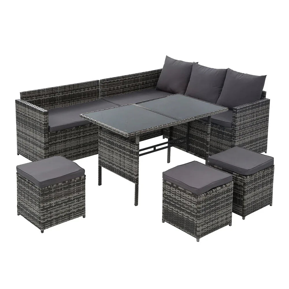 Outdoor 9-seater wicker sofa set arranged in a garden setting with light cushions.