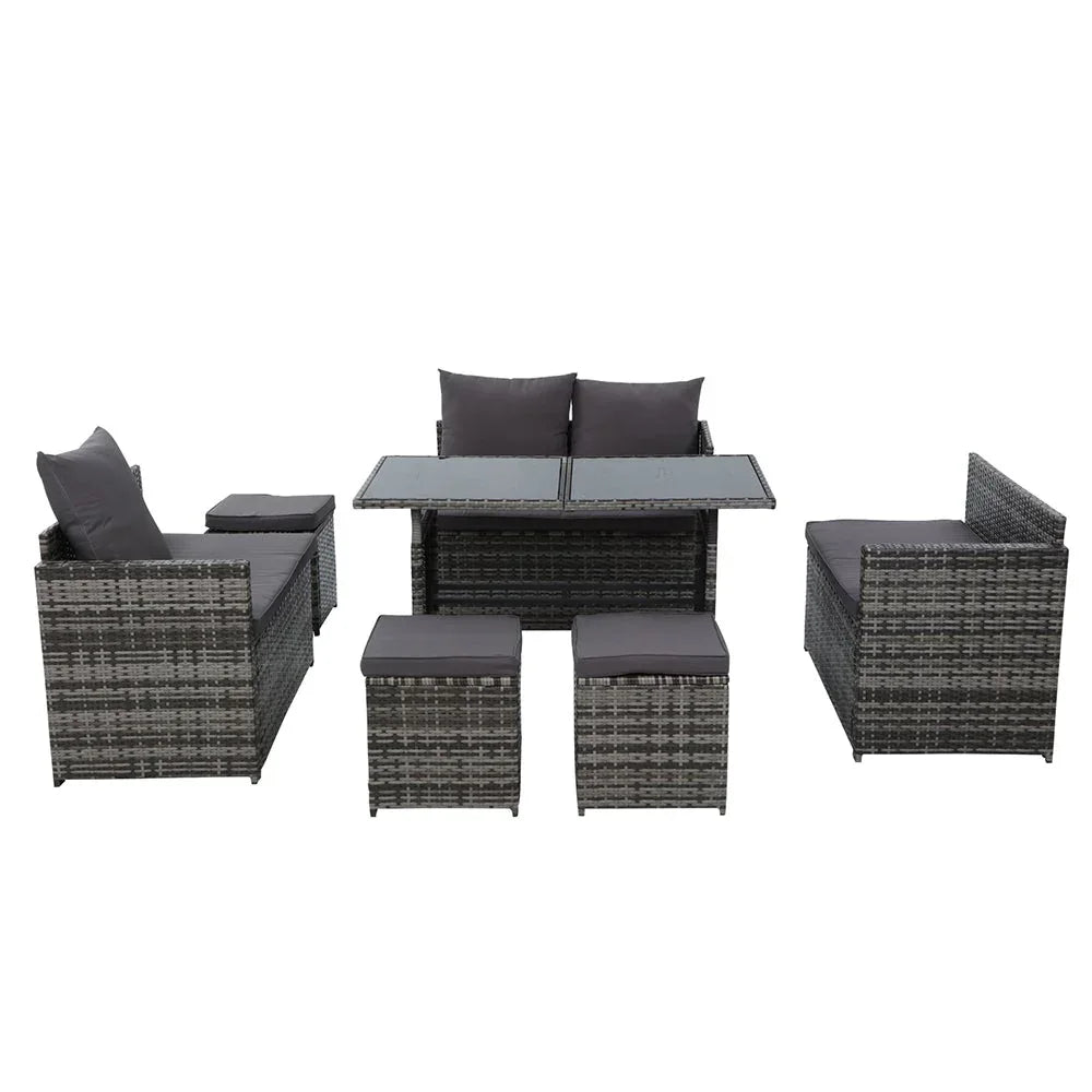Outdoor dining setup with 9-seater wicker sofa and table on patio with plants.