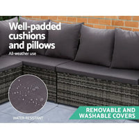Wicker sofa set arranged with table, showing seat hooks securing cushions.