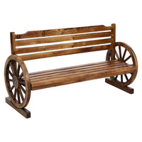 Wooden three-seat garden bench with wagon wheel armrests and rustic finish on a grassy lawn