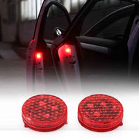 A pair of small, round wireless warning lights attached to the inside edge of an open car door.