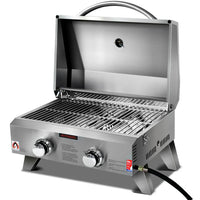Closed portable 2 burner stainless steel gas BBQ with carry handle on a white background.