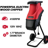 Electric wood chipper in use, chipping wood branches in outdoor garden environment.
