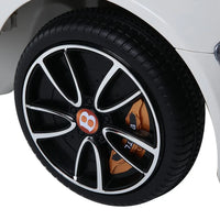 White electric kids car positioned outdoors with open side door and realistic features.