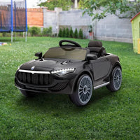 Kids riding black electric ride-on car powered by 12V battery outdoors.