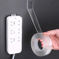 A roll of transparent waterproof double-sided tape unrolled on a white background, showing its strong adhesive side.