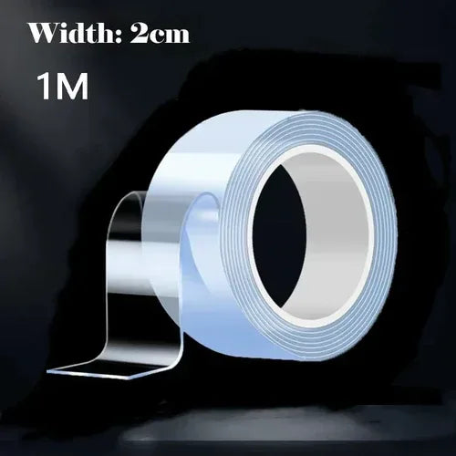 A roll of transparent, reusable double-sided adhesive tape placed on a clean white surface.