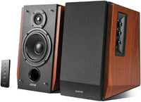 Brown EDIFIER bookshelf studio speakers with Bluetooth, displayed on a wooden surface with remote control.