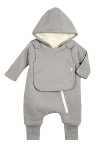 Baby wearing gray fleeced lined jumpsuit with attachable bib sitting on a couch.