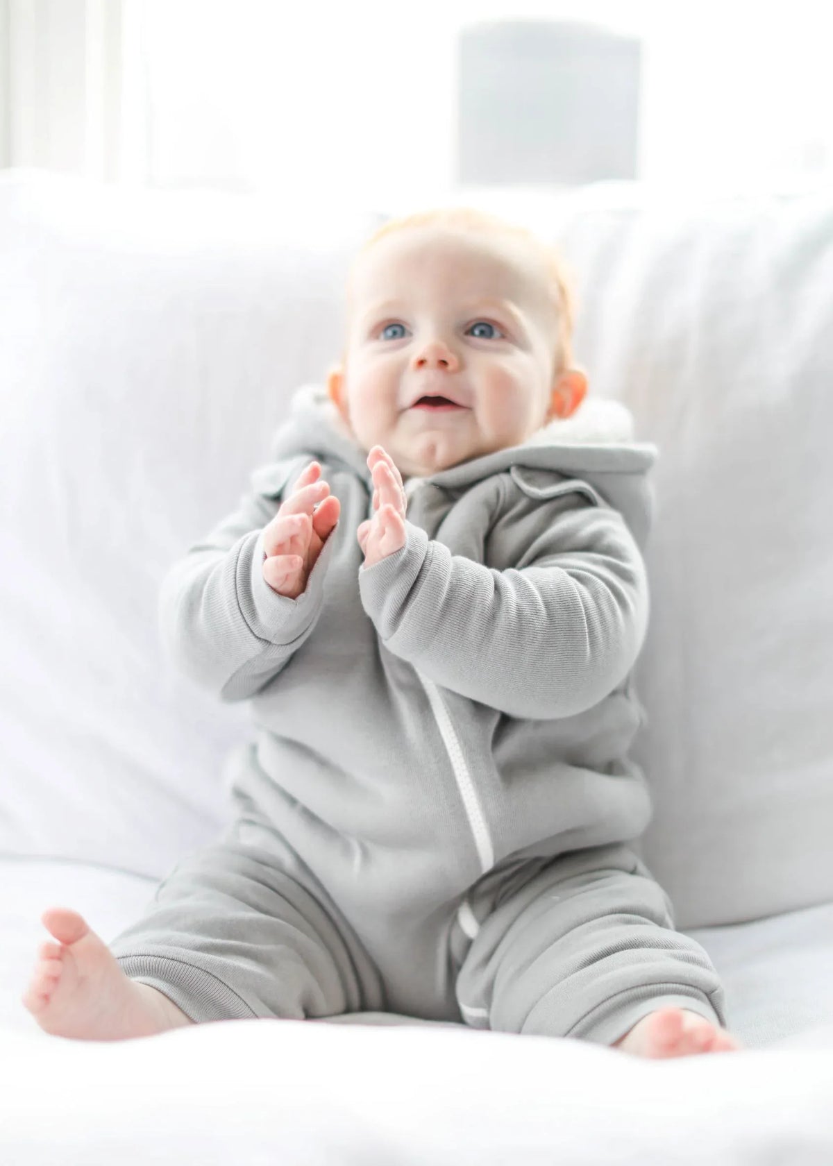 Folded gray fleeced lined jumpsuit displayed with matching bib on white background.