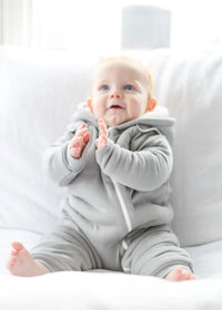 Folded gray fleeced lined jumpsuit displayed with matching bib on white background.