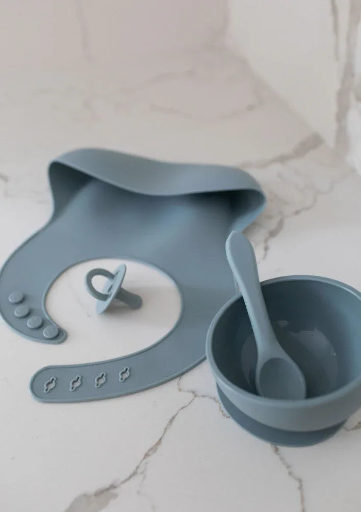 Azul silicone bib in soft blue color, adjustable size, with a neck strap on white background.