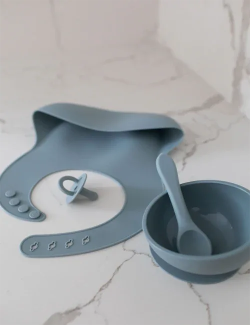 Close-up of turquoise silicone bib showing adjustable neck closure and smooth waterproof surface.