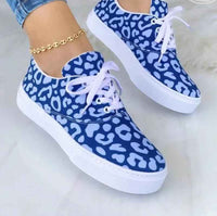 White women's sneakers with colorful graffiti-style designs on the sides, displayed against a plain background.