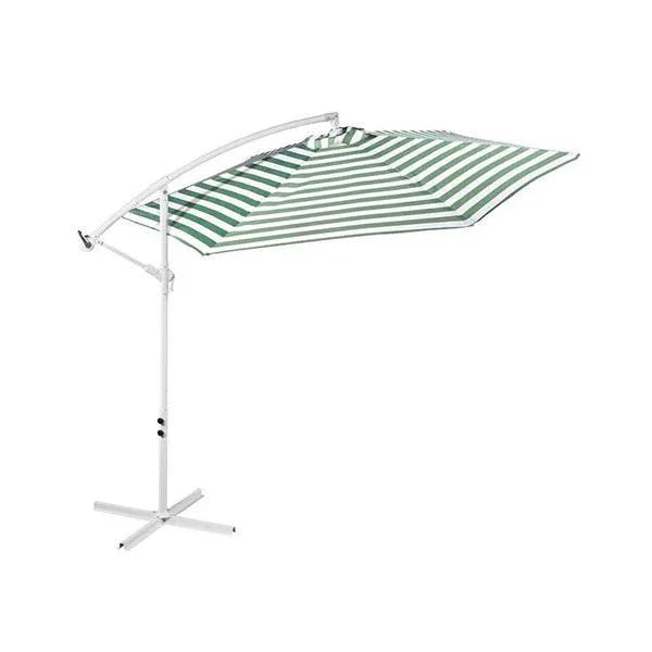 Green and white striped outdoor umbrella providing shade on a garden patio under clear sky.