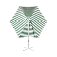 Close-up of green and white striped fabric and steel frame of outdoor garden umbrella.