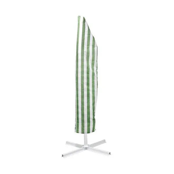 Green and white striped umbrella tilted over patio furniture for sun protection.