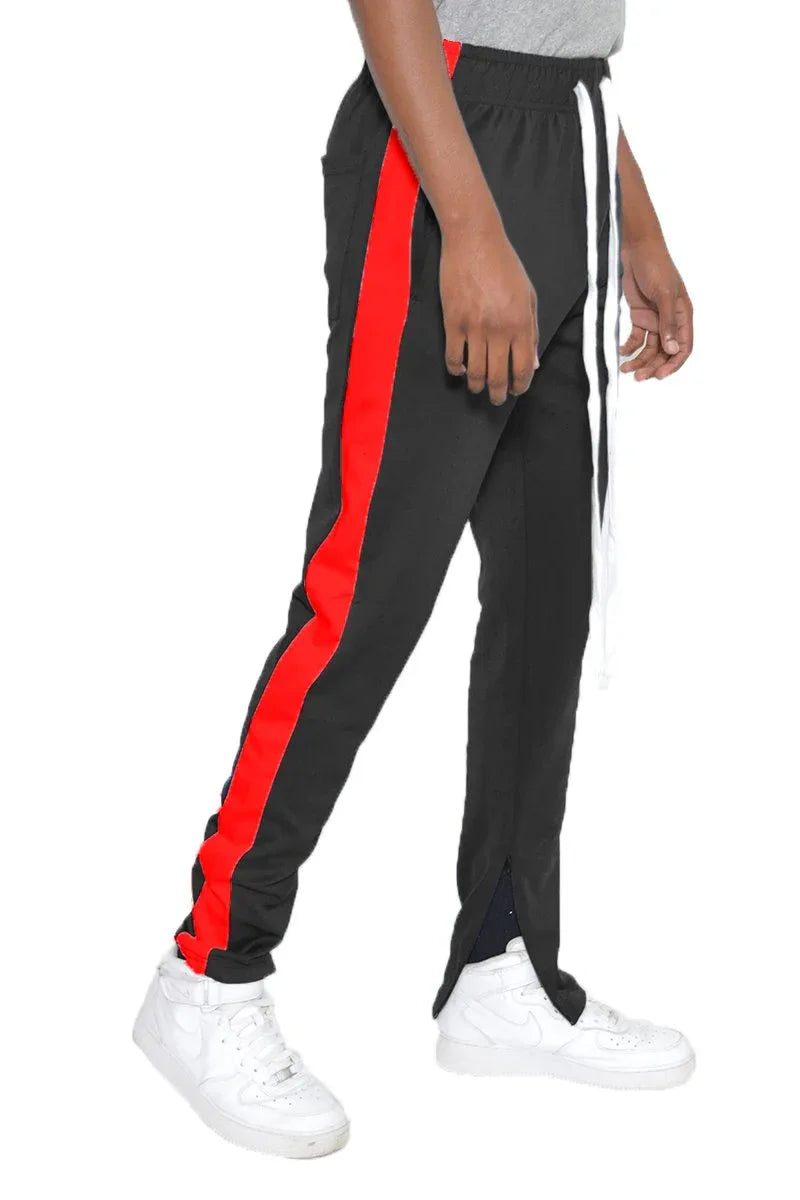 Front view of men's slim fit black track pants with single red stripe, zipper closure, and tapered ankles.