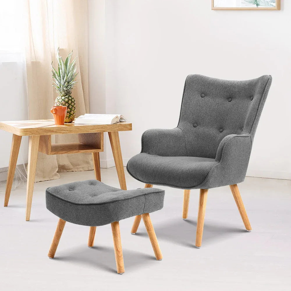 Front view of grey tufted armchair with curved back and matching ottoman
