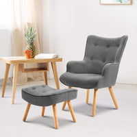 Front view of grey tufted armchair with curved back and matching ottoman