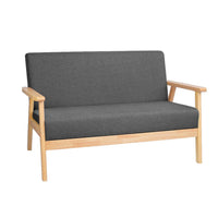 Grey 2-seater fabric sofa chair with soft cushions and wooden legs against a white background.