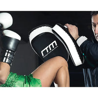 Close-up of hand holding padded curved strike shield for boxing training