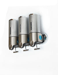 Close-up of the shower dispenser showing three refillable containers labeled for shampoo, conditioner, and body gel.