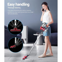 Red and silver Devanti vacuum cleaner with cord coiled beside appliance on light floor.