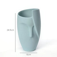 Close-up of white ceramic face planter showing detailed facial features, clean and smooth finish.
