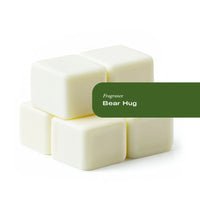 Six Bear Hug wax melt tarts arranged in a circular pattern on a wooden surface.