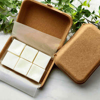 Stacked natural coconut wax melts with warm sunlight casting soft shadows on a wooden surface.