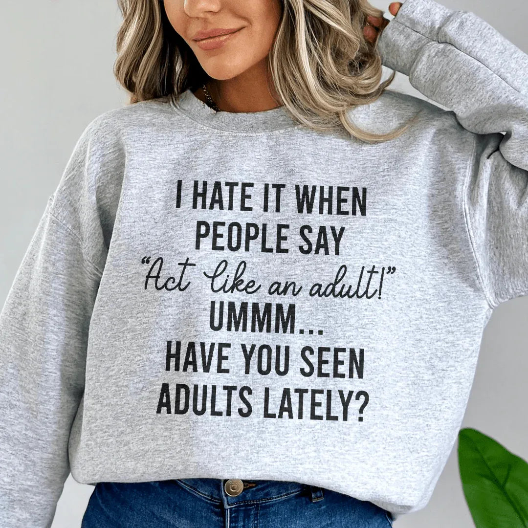 Sport grey sweatshirt with 'Act Like An Adult' text in peach, showcasing warm fleece lining and fitted cuffs.
