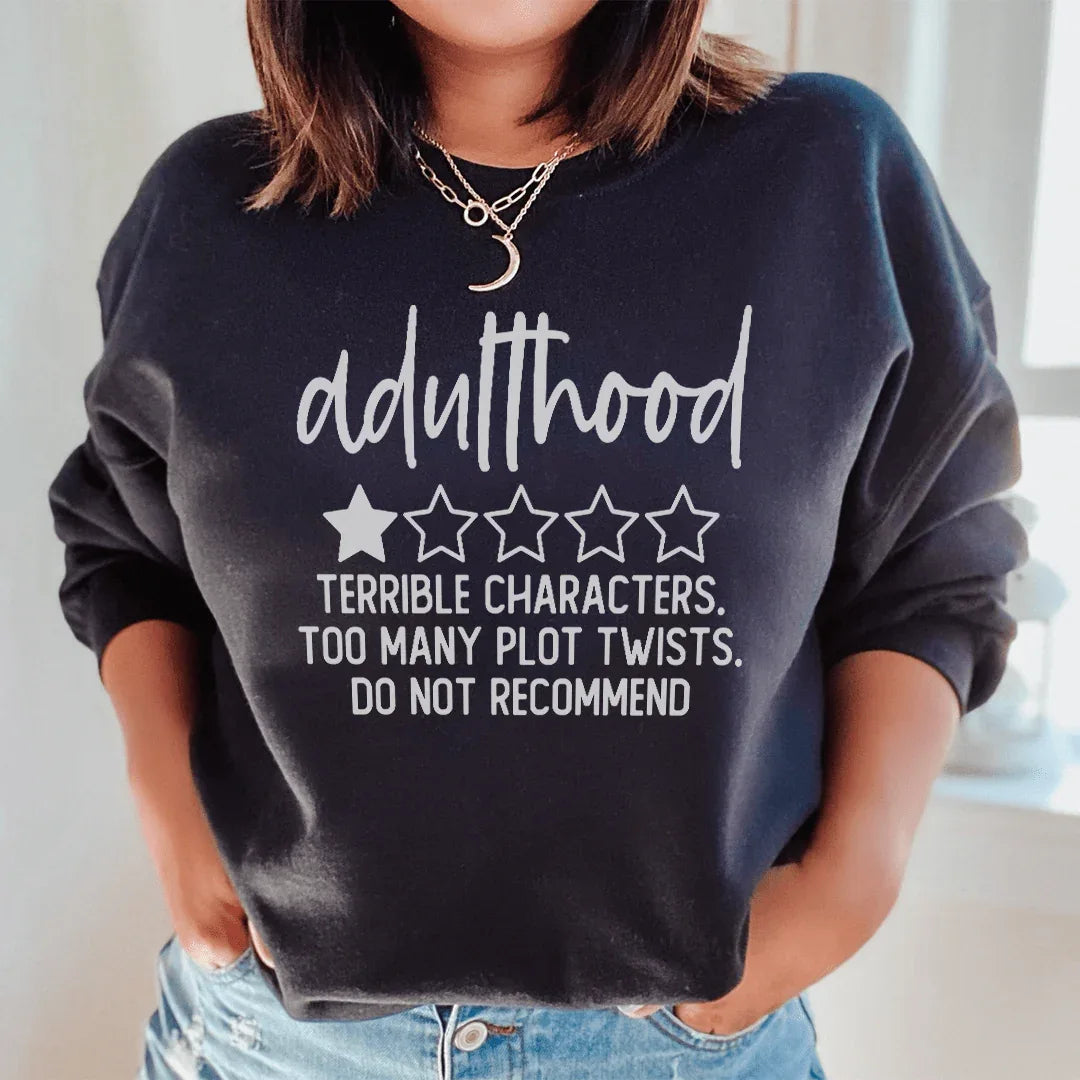 Black sweatshirt with pink and white text reading 'Adulthood Terrible Characters Too Many Plot Twists'