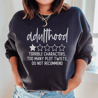 Black sweatshirt with pink and white text reading 'Adulthood Terrible Characters Too Many Plot Twists'