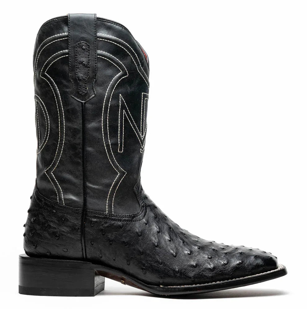 Front angled view of black cowboy boot with ostrich skin on vamp and square toe.