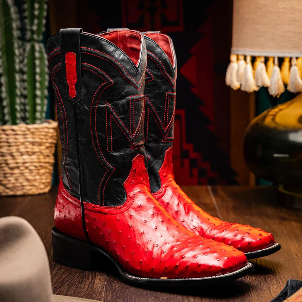 Alabama Red ostrich skin cowboy boot worn with jeans in relaxed pose outdoors.