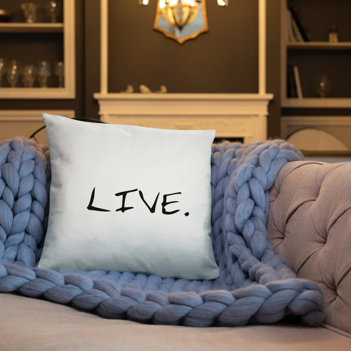 White square pillow on a cream upholstered chair by a window with natural light