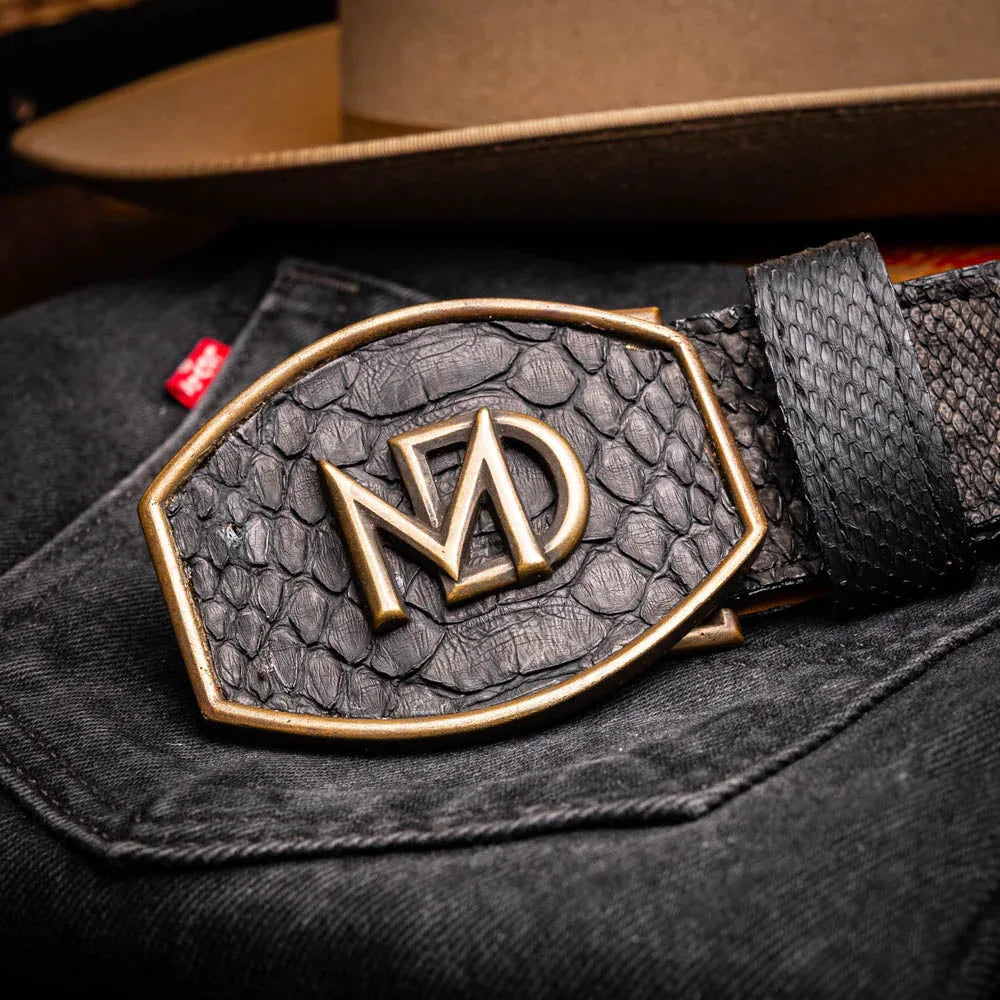 Close-up of person fastening Arkansas black python skin belt with antique brass Western buckle