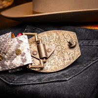 Close-up of the belt buckle and python skin texture worn with casual western outfit.