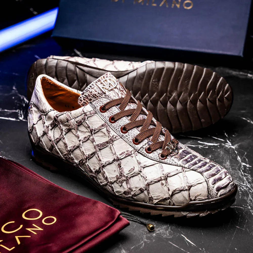 Lifestyle photo of person wearing Batistini sneakers standing on textured ground outdoors.