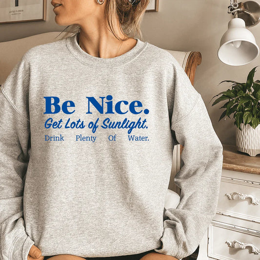 Light grey sweatshirt with colorful text: 'Be Nice Get Lots Of Sunlight Drink Plenty Of Water'