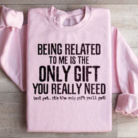 Light pink sweatshirt featuring the quote 'Being Related To Me Is The Only Gift You Really Need' on front.