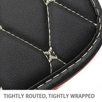 Side view of black car seat protector pad with red stitching showcasing padded design on vehicle seat.