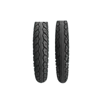 Two black CST electric bike fat tires leaning against a motorcycle wheel.