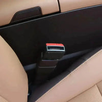 Black fabric car seat belt extender with red push button release shown clearly.