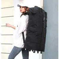 Black rolling foldable luggage bag standing upright with extended handle on white background.