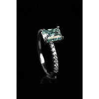 Blue gemstone ring featured on white surface with clear focus on stone