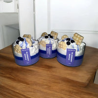 Group of Blueberry Waffle scent candles arranged together on a rustic wooden surface.