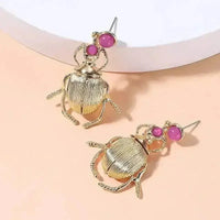 Bohemia earrings showing metal gold plating and delicate beetle design with diamonds.