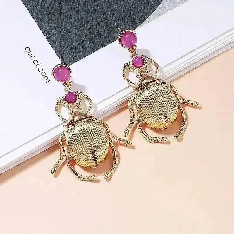 Side view of Bohemia earrings highlighting the gold-plated beetle shape and sparkling diamonds.